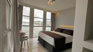 Cama ou camas em um quarto em Grand Hotel Guarujá - A sua Melhor Experiência Beira Mar na Praia!