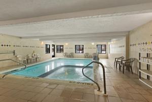 a swimming pool in a building with a no drinking sign on the wall at Quality Inn Traverse City in Traverse City