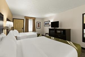 a hotel room with two beds and a flat screen tv at Quality Inn Traverse City in Traverse City