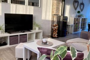 a living room with a tv and a white table at Cozy'Maisonnette * 2 pers Garden'Room in Guipavas