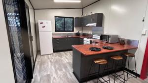a small kitchen with a counter and a refrigerator at Feng Shui Sugarcane Cabin in Proserpine