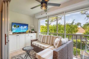 a living room with a couch and a large window at Condo in Naples Near Mercato and Close to Vanderbilt Beach in Naples