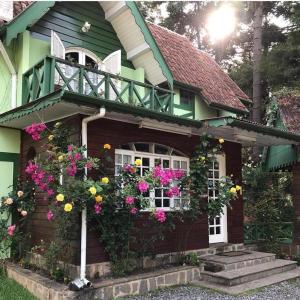 een huis met bloemen aan de zijkant bij Pousada Vale Verde in Campos do Jordão