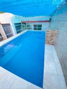 una gran piscina azul con una pared de ladrillo en Apartamento entero en Caacupé. en Caacupé