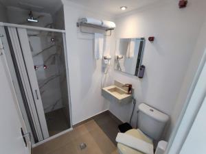 uma pequena casa de banho com WC e lavatório em Grand Hotel Guarujá - A sua Melhor Experiência Beira Mar na Praia! no Guarujá