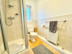 a bathroom with a shower and a toilet at 4 bedroom home just off the M20 easy access to Dover & Eurotunnel central Ashford & parking in Ashford