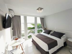 Cama ou camas em um quarto em Grand Hotel Guarujá - A sua Melhor Experiência Beira Mar na Praia!