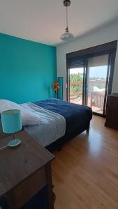 a bedroom with a bed and a table and a window at PISÓN PDD in Punta Del Diablo