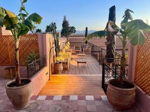 un balcón con sillas, mesas y plantas. en Riad Ecila, en Marrakech