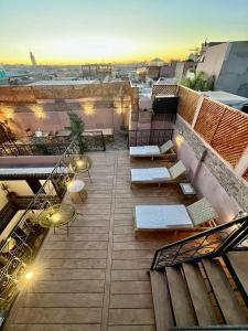 Un balcón con sillas y mesas en un edificio en Riad Ecila, en Marrakech