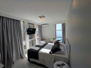 Cama ou camas em um quarto em Grand Hotel Guarujá - A sua Melhor Experiência Beira Mar na Praia!