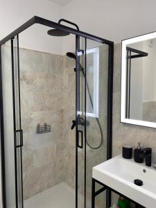 a shower with a glass door next to a sink at Apartament 33 Nad Iławką in Iława