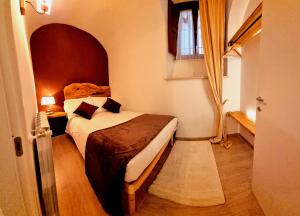 - une petite chambre avec un lit et une fenêtre dans l'établissement Dimora Grotta Masciarelli, à LʼAquila
