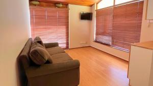 a living room with a couch and two large windows at Kabana Family Home and Guest House in Cape Town