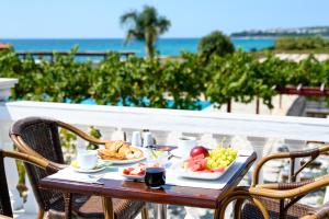 una mesa con una bandeja de comida en el balcón en Poseidon Beach Hotel, en Kastrosikia