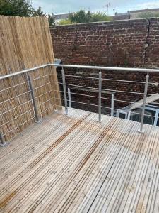 a wooden deck with a fence and a bench at Appartement standing Le Havre in Le Havre