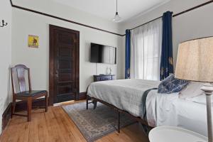 a bedroom with a bed and a chair and a television at Downtown Gillett Bungalow, Fireplace, 3B, Historic in Gillett