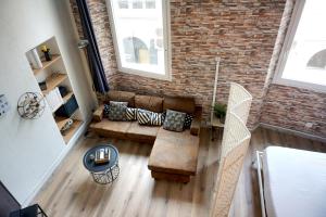 uma sala de estar com um sofá e uma parede de tijolos em Le Massilia de Steenia em Marselha
