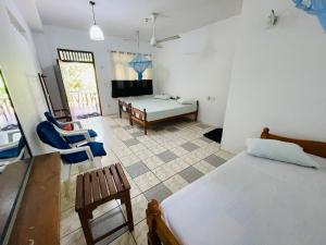 1 dormitorio con 1 cama, mesa y sillas en Temple Flower Guest, en Kirinda