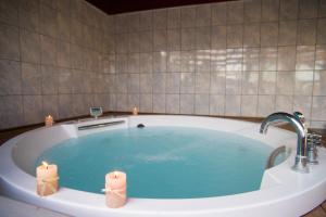 a bathroom with a tub with two candles in it at Poseidon Beach Hotel in Kastrosikia