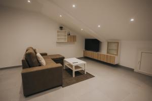 sala de estar con sofá y TV en Casas del Pedregal, en A Estrada