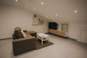 a living room with a couch and a tv at Casas del Pedregal apartamento 3 in A Estrada