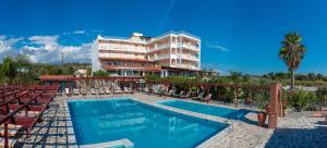 a hotel with a swimming pool in front of a building at Poseidon Beach Hotel in Kastrosikia