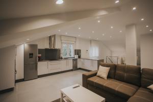 a living room with a couch and a kitchen at Casas del Pedregal apartamento 3 in A Estrada +30 photos