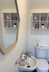 a bathroom with a sink and a toilet and a mirror at Stylish Family Beach House - 200m to the Beach in Mudjimba