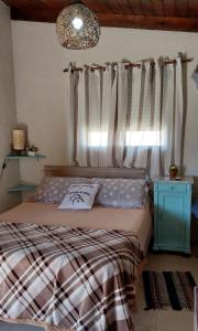 Schlafzimmer mit einem Bett und einem Fenster mit Vorhängen in der Unterkunft Descanso al Paso Chuy in Chuy