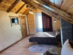 sypialnia z 2 łóżkami w drewnianym domku w obiekcie Цісарка w mieście Mikuliczyn