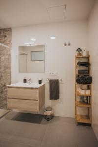 La salle de bains est pourvue d'un lavabo et d'un miroir. dans l'établissement Casas del Pedregal, à A Estrada