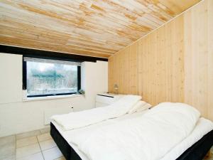 Ce lit se trouve dans un dortoir doté d'un plafond en bois. dans l'établissement Holiday home Jægerspris XXIII, à Jægerspris