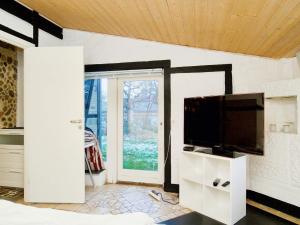 sala de estar con TV de pantalla plana en la pared en Holiday home Jægerspris XXIII, en Jægerspris