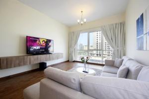 a living room with a couch and a tv at THE 407 Room in Dubai