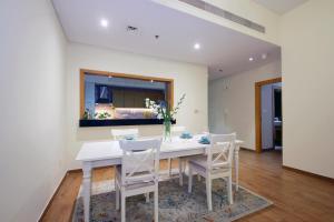 a dining room with a white table and chairs at THE 407 Room in Dubai