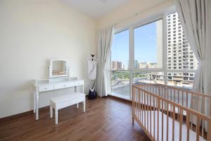 Habitación blanca con escritorio y ventana grande. en THE 407 Room, en Dubái