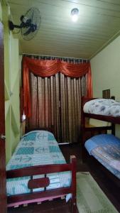 a bedroom with two bunk beds and a window at Pousada Avalon Paranapiacaba in Paranapiacaba