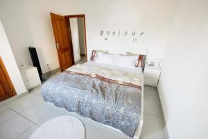 a bedroom with a bed and a sign on the wall at Bienvenue Chez NeEm Studio : ) (Douala-Ndogbong) in Douala
