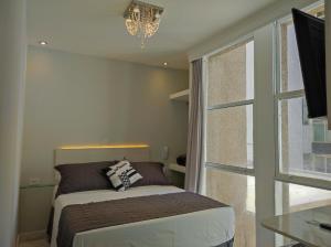 Cama ou camas em um quarto em Grand Hotel Guarujá - A sua Melhor Experiência Beira Mar na Praia!