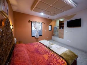 a bedroom with a bed and a television in it at Hotel el Ángel Taxco in Taxco de Alarcón