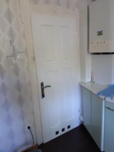 a white door in a kitchen with a sink at Biały apartament in Polanica-Zdrój