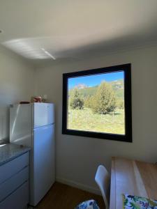 a kitchen with a window and a white refrigerator at Meliquina Home in Villa Meliquina