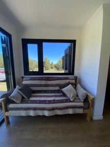 a bed in a room with a large window at Meliquina Home in Villa Meliquina