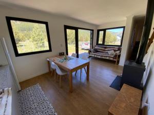 un soggiorno con tavolo, sedie e divano di Meliquina Home a Villa Lago Meliquina