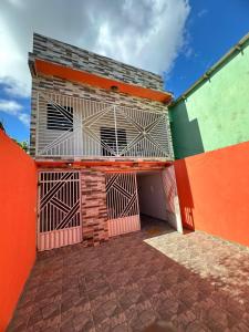 un edificio con una pared de color naranja y verde en Casa - Peroba, en Maragogi