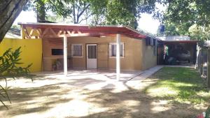 una pequeña casa amarilla con techo rojo en Casa El Sueño, en Ituzaingó