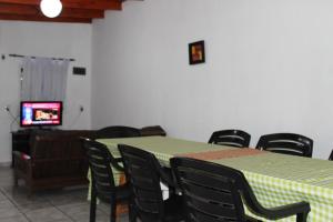 Una habitación con una mesa y sillas y un televisor. en Casa El Sueño, en Ituzaingó 6 fotos más