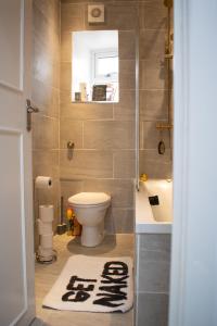 a bathroom with a toilet and a sink and a tub at SW Stay - Stylish One Bedroom with patio in London