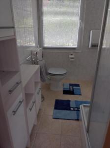 uma casa de banho com WC e toalhas azuis no chão em Ferienhaus Oscar em Ahlbeck